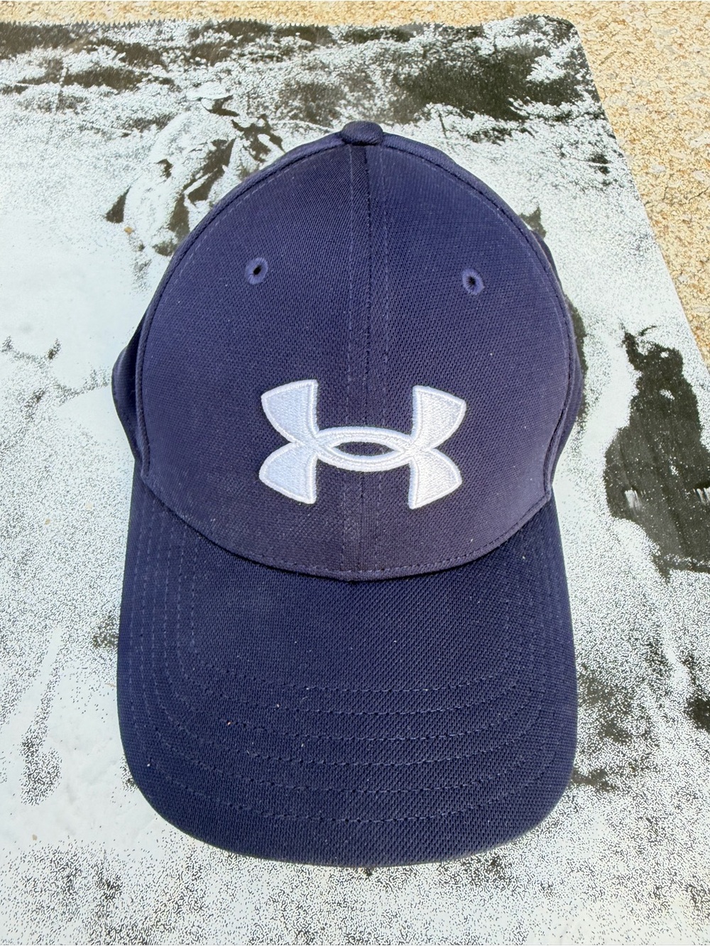 navy blue Under Armour Men's Blitzing Cap featuring a prominent white embroidere
